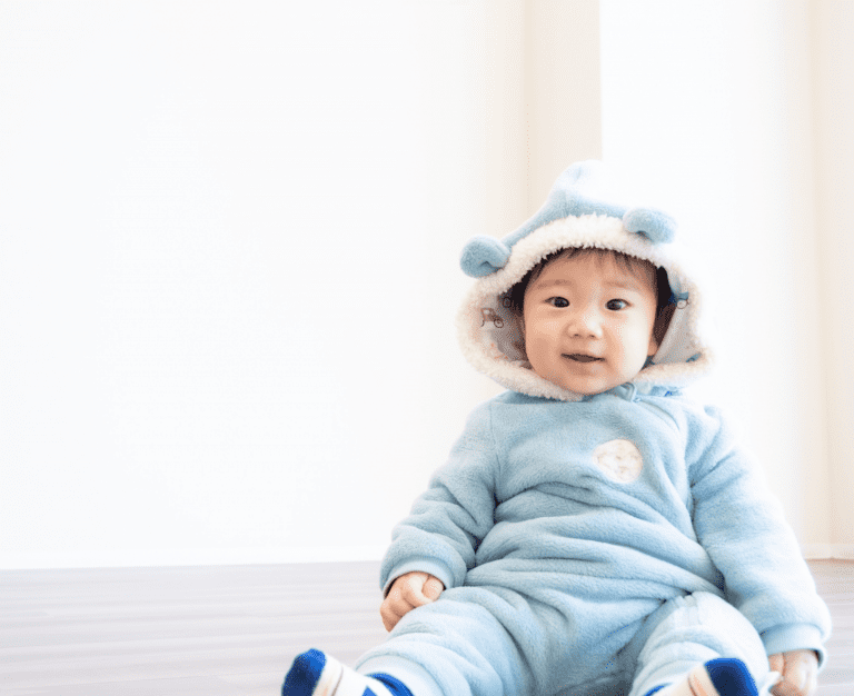 青色の服を着た赤ちゃんの写真